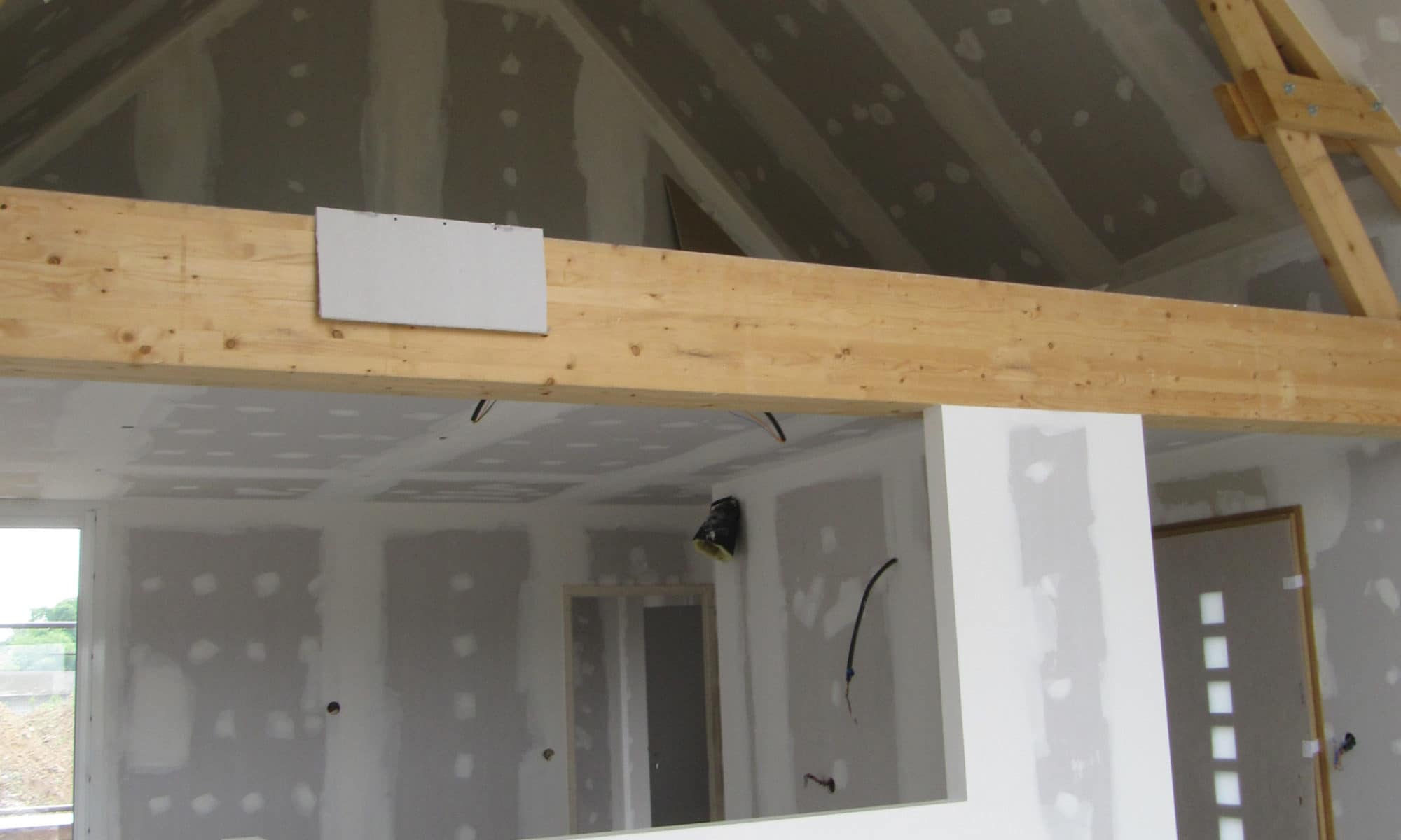 Intérieur en construction avec mansarde et plaques de plâtre.
